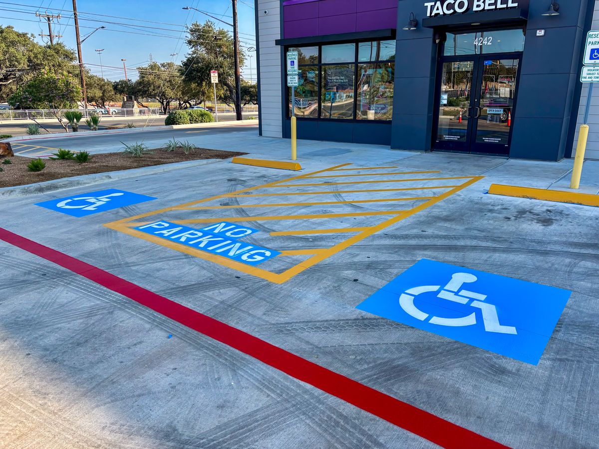 ADA handicap parking spots with blue symbols, yellow access aisles, and red fire lane curb