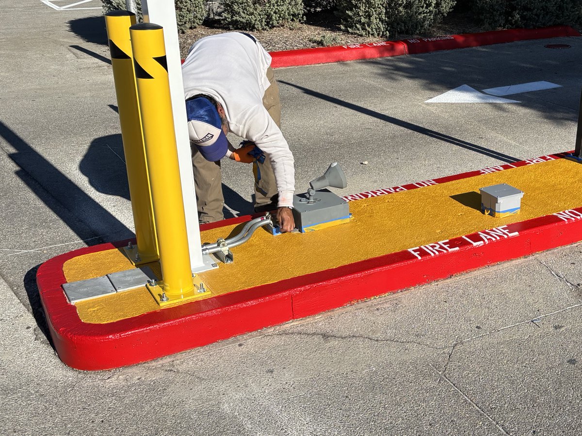 Island painted with a yellow top and a red fire lane curb stenciled FIRE LANE