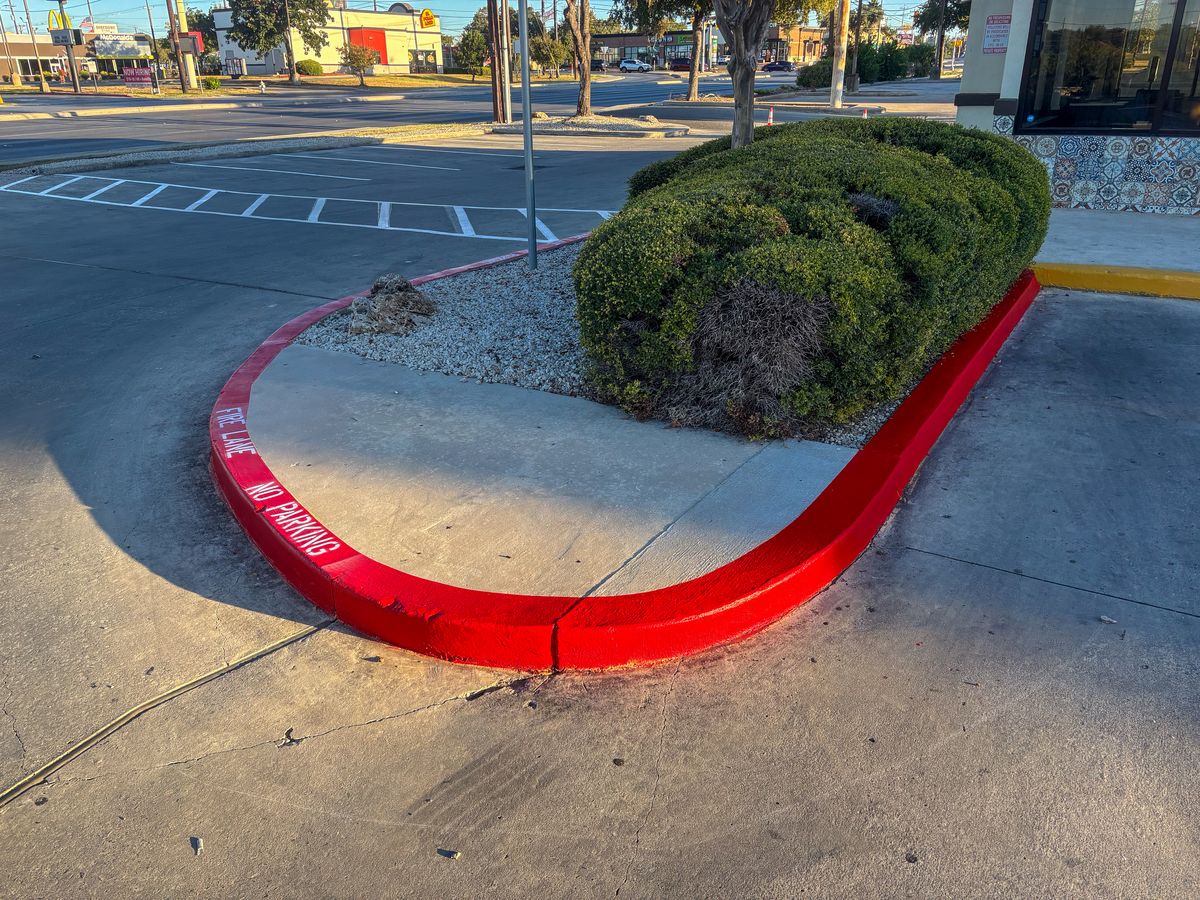 Red fire lane curb with NO PARKING text
