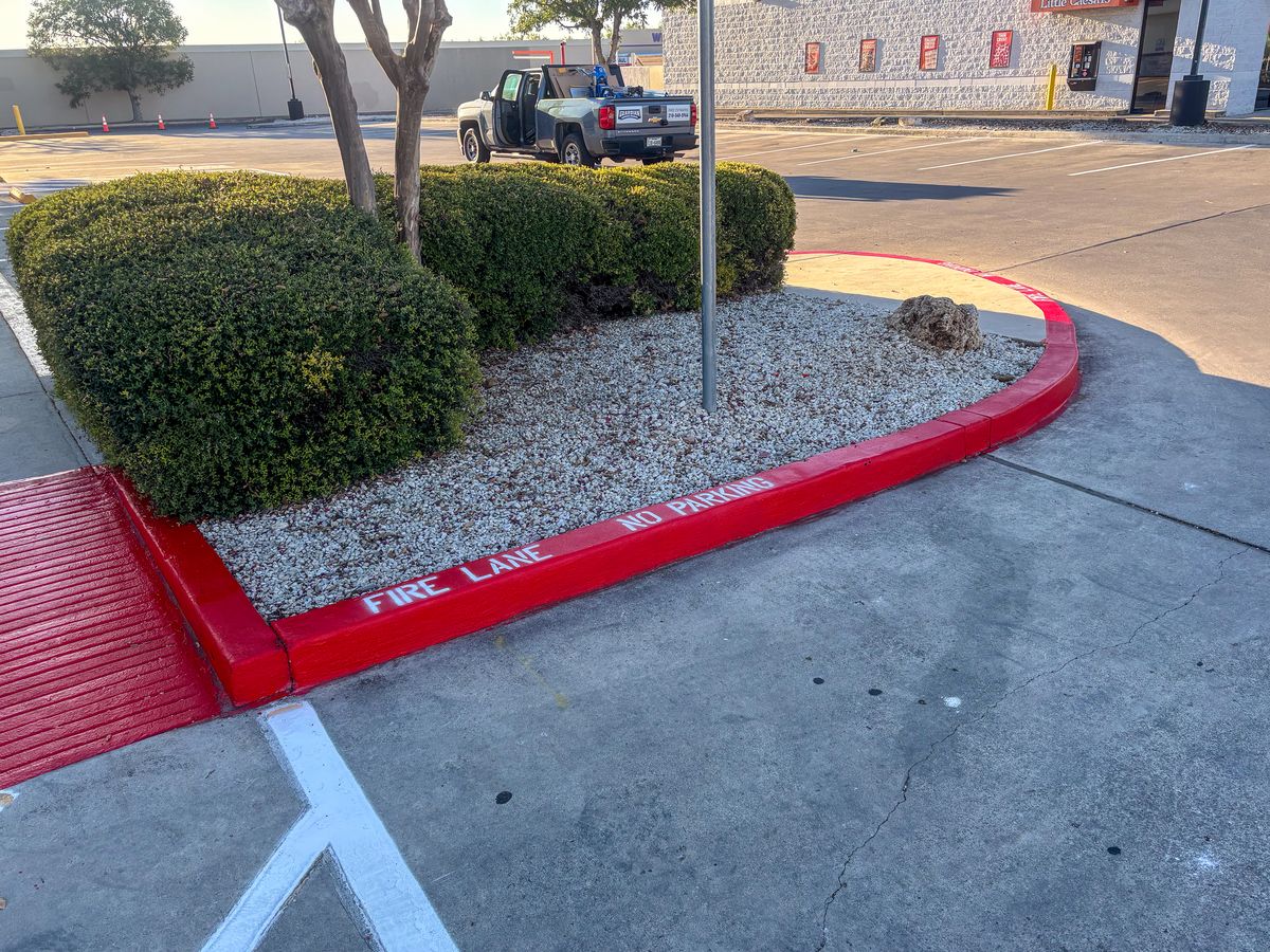 Red fire lane curb painting with NO PARKING stencil