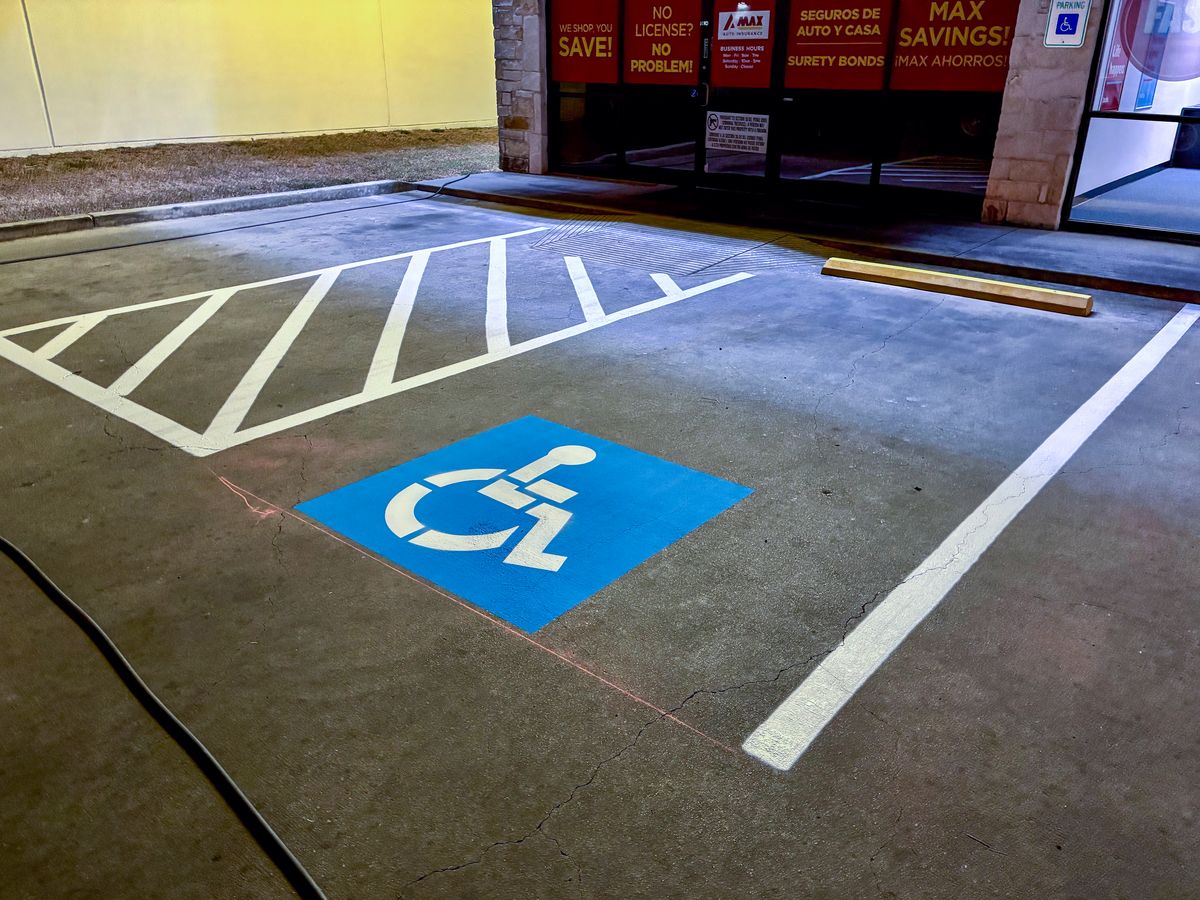 ADA handicap stall with blue wheelchair symbol and access aisle
