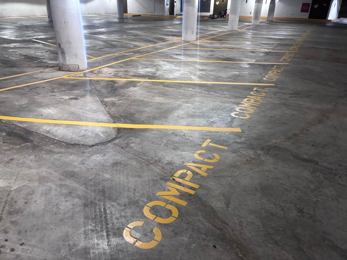 Restriped stall lines and COMPACT stencils in a parking garage