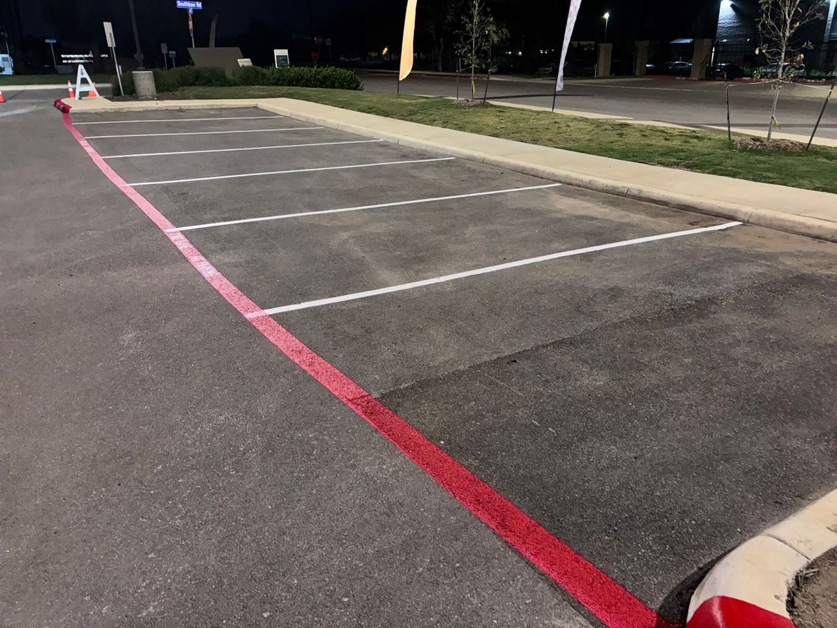 Freshly striped stalls and red fire lane at a residential community leasing office