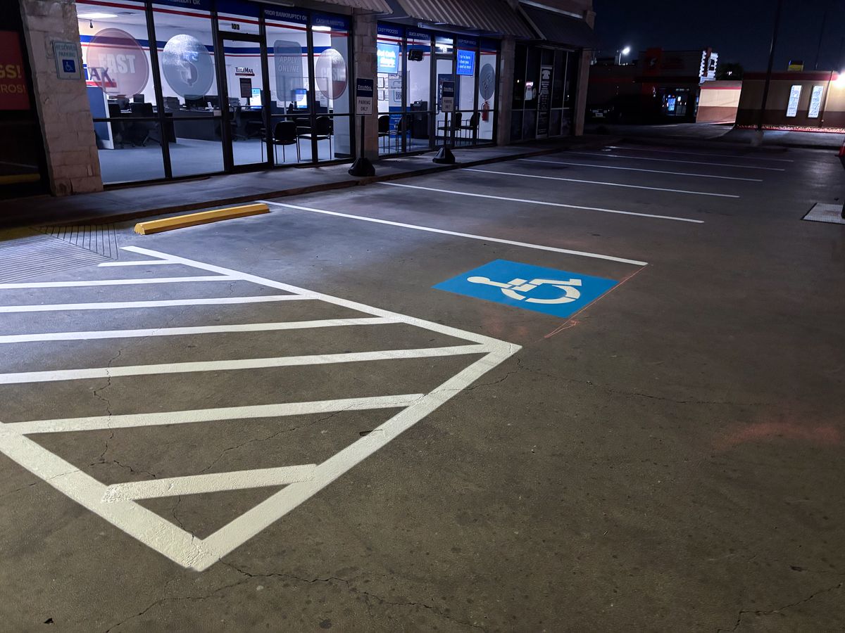 Dark parking lot surface with fresh white striping