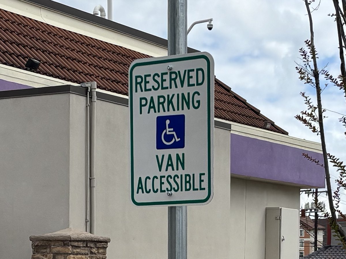 Reserved parking van accessible sign installed on a steel post