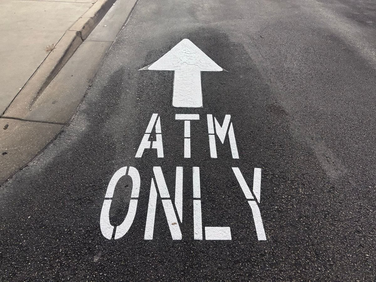 ATM ONLY stencil and arrow freshly painted in a drive-thru lane
